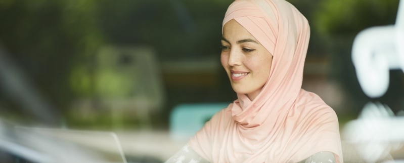 Woman wearing a hijab working on a laptop